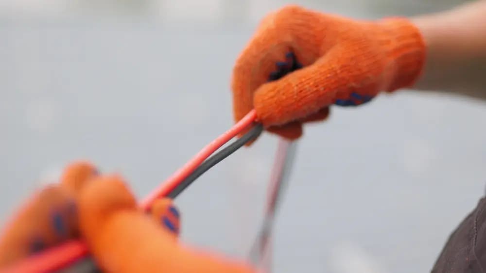 electricista sostiene cable eléctrico