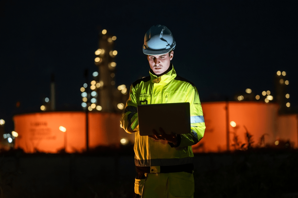 trabajador en una industria de noche con un ordenador